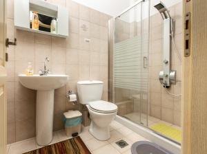 y baño con aseo, lavabo y ducha. en Central Cozy Apartment en Sparti