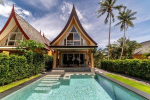 a house with a swimming pool in front of a house at Siam Royal View Villas in Ko Chang