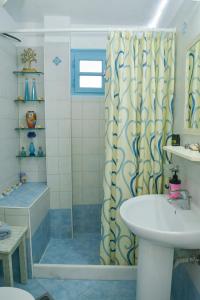 a bathroom with a shower curtain and a sink at nikola's house in Adamantas