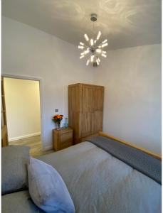 a bedroom with a bed and a chandelier at Near Woodbridge The Annexe Eyke Fantastic views with Dog secure Garden and Paddock in Eyke