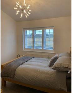 a bedroom with a bed and a chandelier at Near Woodbridge The Annexe Eyke Fantastic views with Dog secure Garden and Paddock in Eyke