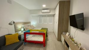 Habitación pequeña con cama y TV. en Loft en Las Canteras, en Las Palmas de Gran Canaria
