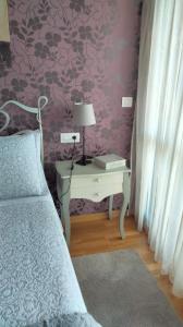 a bedroom with a bed and a table with a lamp at Apartamento Mirador de Padin in Ribeira