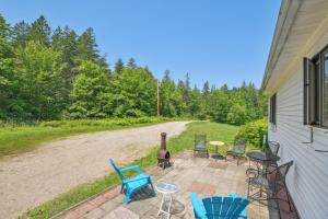 a patio with chairs and a grill next to a house at Charming and Scenic Gouldsboro Getaway with Patio! in Gouldsboro