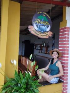 Una mujer con sombrero sentada en el mostrador de un restaurante en HOTEL CAMPESTRE ABRAZO DEL ANGEL en Aratoca