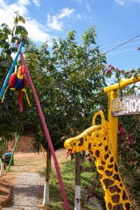 una jirafa de juguete y un columpio en un parque infantil en HOTEL CAMPESTRE ABRAZO DEL ANGEL, en Aratoca