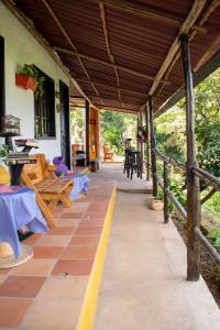 a porch of a house with tables and benches at HOTEL CAMPESTRE ABRAZO DEL ANGEL in Aratoca