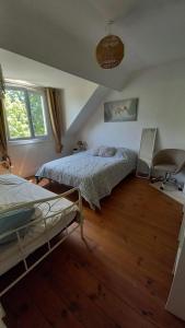 1 dormitorio con 2 camas y 1 silla en Gîte des Tanneurs, en Nogent-le-Rotrou