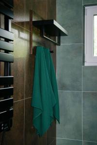 toalla verde colgada en la pared del baño en STOLEMOWE Wzgórze Domek Leśnika, en Perlino