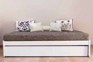 a white bed with pillows on it in a room at Raisakis Apartments in Agia Marina Nea Kydonias