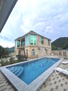 a house with a swimming pool in front of a house at Raffles Villa with pool in Gabala