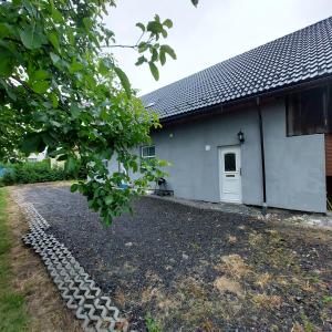 ein Haus mit Kieseinfahrt neben einem Gebäude in der Unterkunft Szary Domek 2 in Wieprz