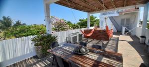 Casa con Piscina Privada Playas del Mar في كارتاهينا دي اندياس: شرفة مع مقعد خشبي وأرجوحة