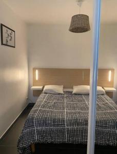 a bedroom with a bed with a black and white comforter at Studio(1) cosy, 2 pers aéroport Marseille in Marignane