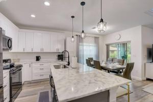 a kitchen with white cabinets and a table with chairs at Modern Vacation House in Rotonda West