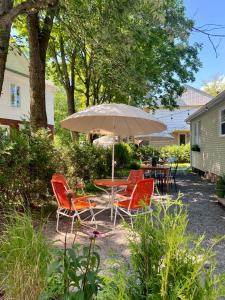 a table and chairs with an umbrella in a yard at Le Loft par Maison Dudley in Lac-Mégantic +17 photos