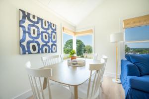 uma sala de jantar com uma mesa e um sofá azul em Marina Bay Cottages em Waterford