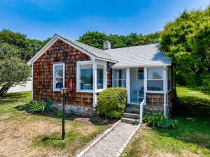 een klein houten huis met een tuin bij Marina Bay Cottages in Waterford