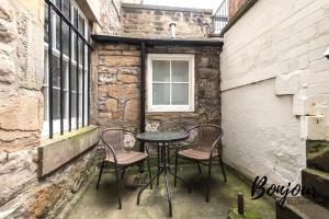 einen Tisch und zwei Stühle auf einer kleinen Terrasse in der Unterkunft Montmartre Suite - New Town 3BR-3BA Main Door - Free Parking & Patio by Bonjour Residences Edinburgh in Edinburgh
