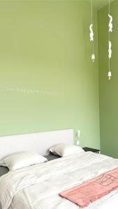 1 dormitorio con 1 cama con pared verde en Fluwine en Hooglede