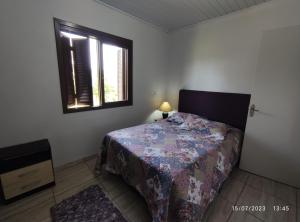 a bedroom with a bed and a window at Casa térrea em meio ao verde! in Encantado
