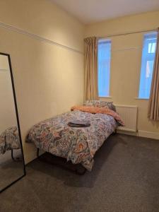 Schlafzimmer mit einem Bett und einem Spiegel in der Unterkunft Modern 3BD London Flat in London