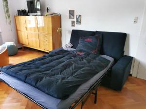 a bed in a living room with a couch at Gundis Gästezimmer in Bamberg