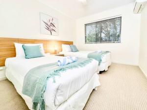a bedroom with two beds and a window at Poolside Retreat at Tropical Resort 126IP in Noosaville +23 photos