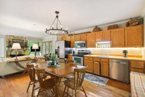 a kitchen with wooden cabinets and a table and chairs at Lakefront Hamilton Cabin w/ Dock & Fire Pit! in Hamilton