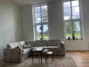 ein Wohnzimmer mit einem Sofa und 2 Fenstern in der Unterkunft Skolan i Näsby lägenhet D in Lövestad