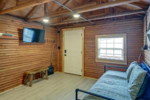 Habitación con cama, TV y puerta. en Cozy Cabin with Direct ATV Trail Riding and Mtn Views!, en Caryville