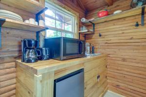 cocina con paredes de madera y encimera con microondas en Cozy Cabin with Direct ATV Trail Riding and Mtn Views!, en Caryville