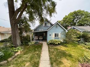 a blue house with a tree in the yard at Casa Madre Chic Lakefront Cottage near Ann Arbor in Whitmore Lake