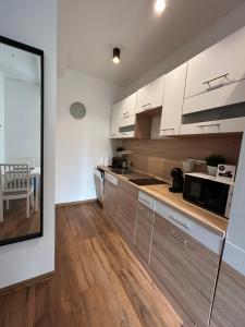 een keuken met witte kasten en een eetkamer bij R59 Apartman with free parking in Pécs