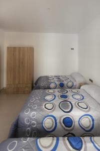 1 dormitorio con 2 camas individuales y almohadas azules y blancas en apartamentos El-Hizan, en Laujar de Andarax