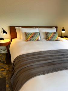 a bedroom with a large bed with pillows at Artisan Suites on Bowen in Bowen Island