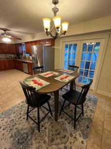 a kitchen with a wooden table with chairs and a refrigerator at Poolside Paradise & Beach Bound in Seminole
