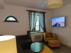ein Wohnzimmer mit einem TV und einem Stuhl in der Unterkunft Le Petit Nid de Nant in Nant