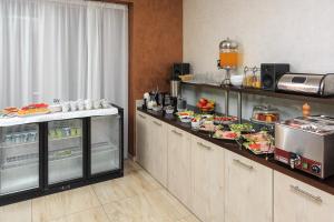 una cocina con buffet con comida. en Hotel Maksim, en Herceg-Novi