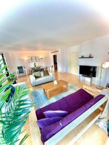 a living room with a purple couch and a table at Spacious Two Bedroom Apartment in London