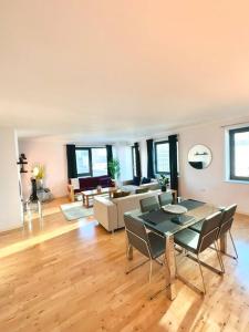 a large living room with a table and chairs at Spacious Two Bedroom Apartment in London