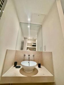 a bathroom with a sink and a large mirror at Spacious Two Bedroom Apartment in London
