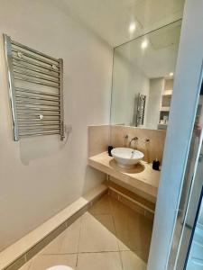 a bathroom with a sink and a mirror at Spacious Two Bedroom Apartment in London