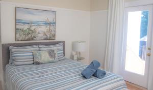 una cama con un osito de peluche azul sentado en ella en Your Cozy and Relaxing Retreat, en Woburn
