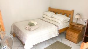 1 dormitorio con 1 cama con toallas en Coco Mango Suites en Portsmouth