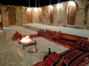 Little Petra Heritage Village في وادي موسى: غرفة مع حفرة نار في مبنى