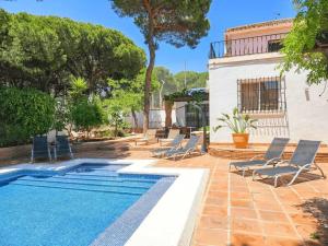 a swimming pool with lounge chairs next to a house at Villa Fuente Verde in Marbella