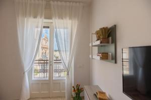 a living room with a window with white curtains at Central House intero appartamento in Ispica