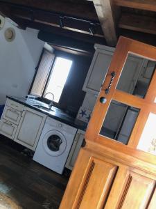 cocina con lavadora y puerta de madera en Tela Marinera, en Lastres