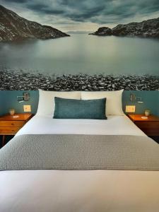 a bedroom with a large bed and a body of water at Artisan Suites on Bowen in Bowen Island